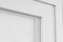 The corner of a white Pella 350 Series vinyl window featuring the removal of a raised weld.