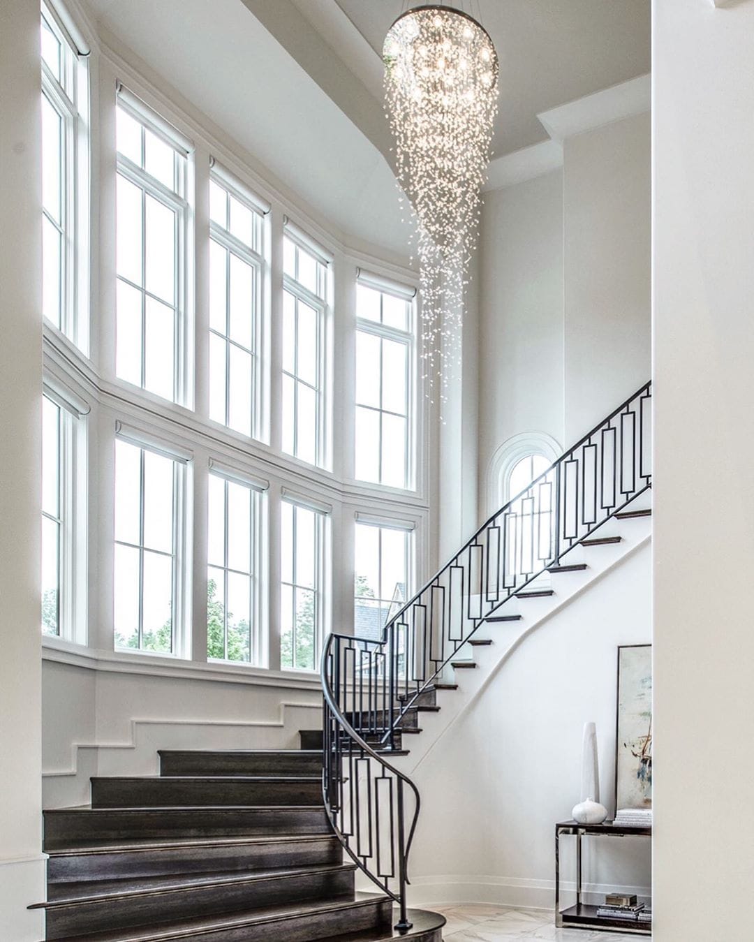 White Fixed Windows Enhance Grand Staircase grand staircase overlooking two rows of white fixed windows bringing in natural light