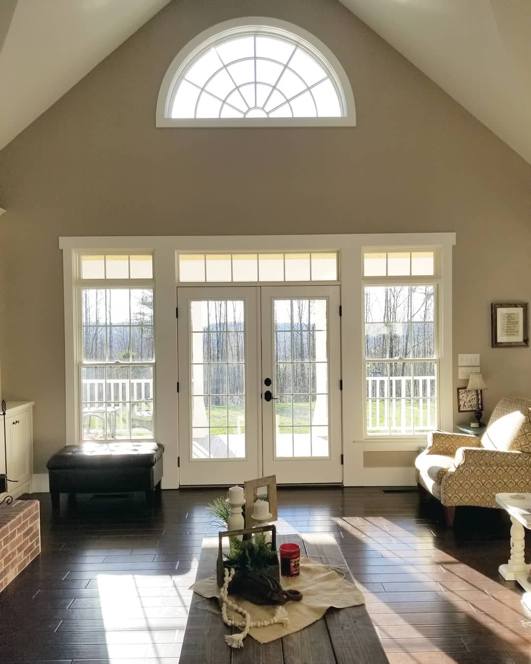 Classic French Doors & Windows Bring Light Into Living Room traditional living room with white french doors surrounded by white windows on either side