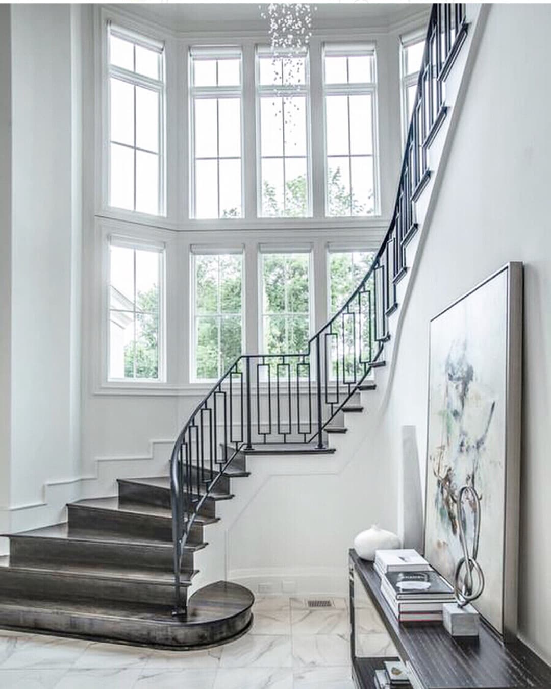 White Window Wall Creates Elegant Stairway curved wall full of white windows with a grand carpeted staircase
