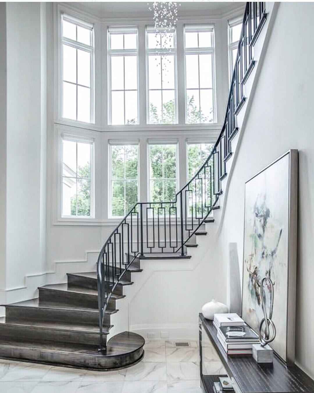 White Window Wall Creates Elegant Stairway curved wall full of white windows with a grand carpeted staircase