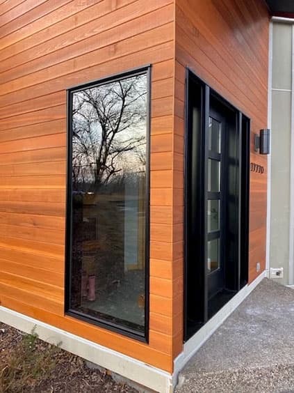Image of a newly installed front door and black window for a Minnetonka modern home.