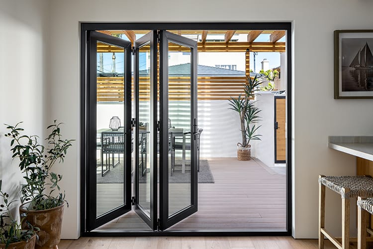 a five-panel bifold patio door in natural wood finish with 1 panel on the left and 4 on the right