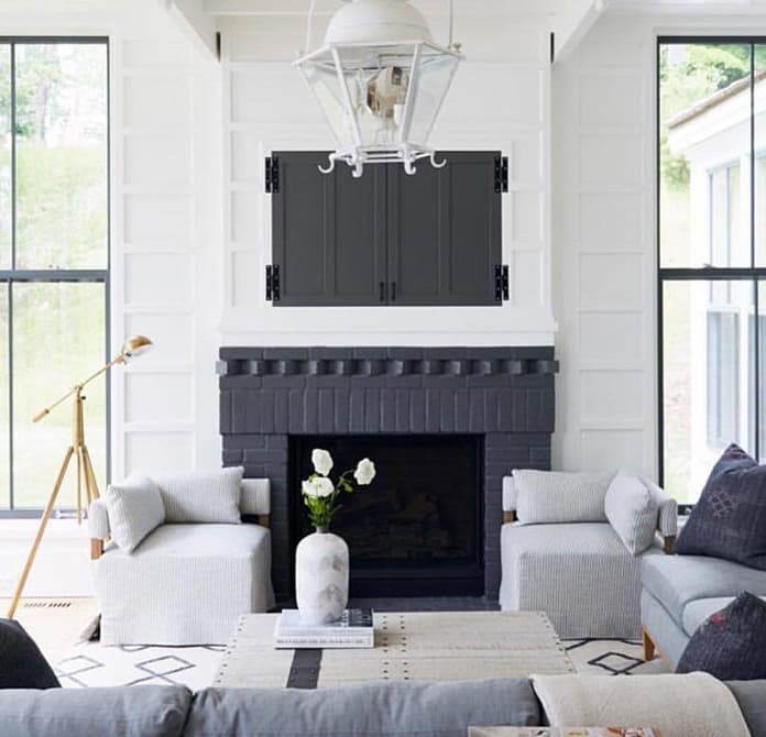 Floor-To-Ceiling Black Windows Bring Symmetry To Living Room white walls black fireplace with large black double-hung windows on either side in contemporary living room