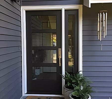 Black Front Door Enhances Home's Modern Aesthetic Modern black front door with four glass panels on blue house