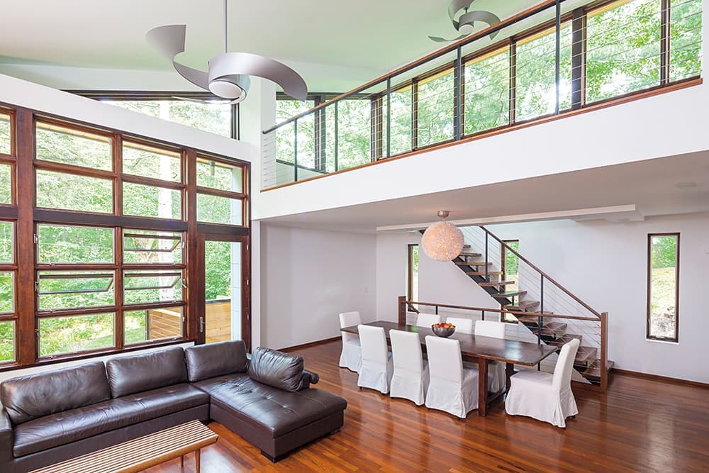 The interior of a mid-century modern home with a wood window wall featuring stacked awning windows.