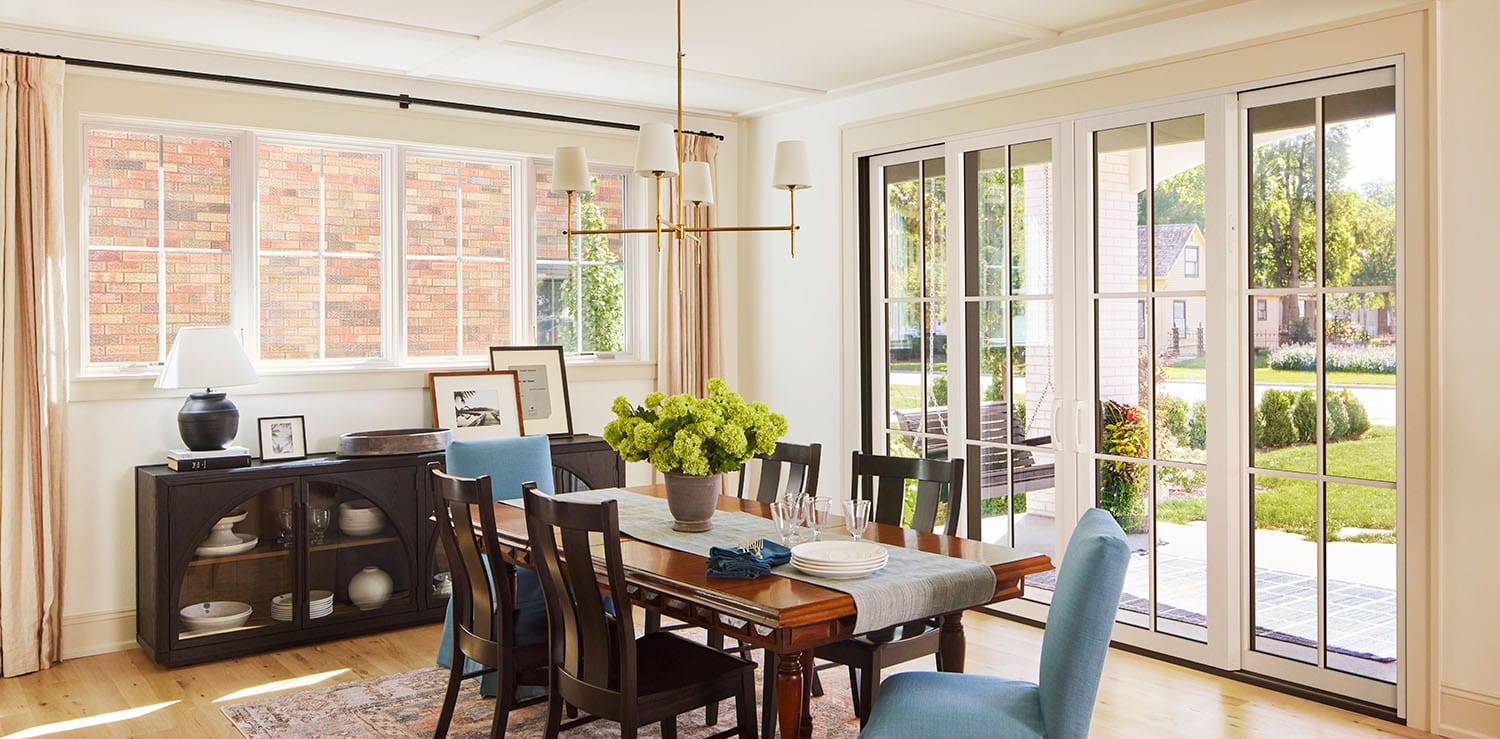 Columbus dining room with large windows and a wooden table set with blue chairs.