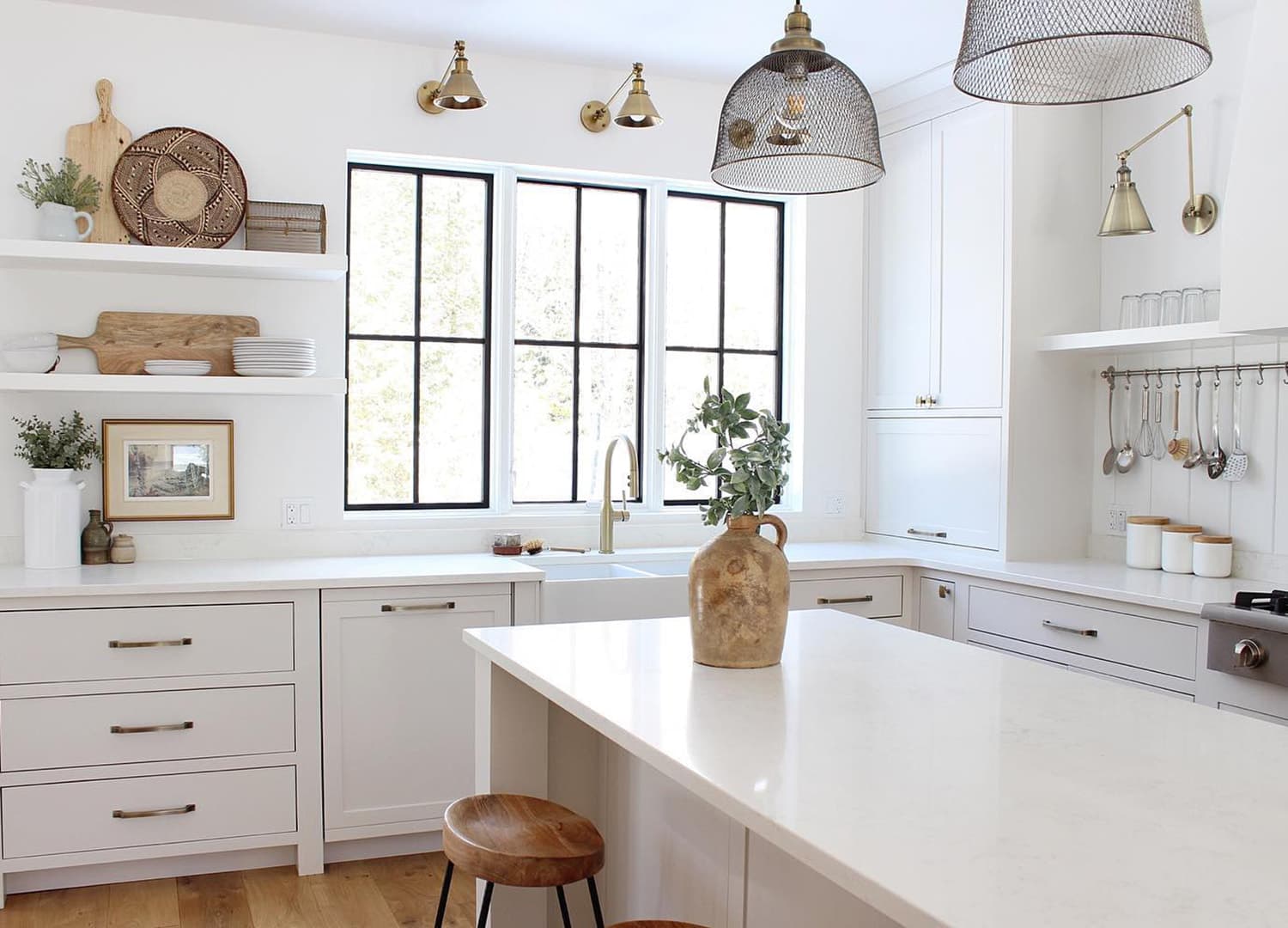 Black grille windows in white kitchen with wood accent pieces