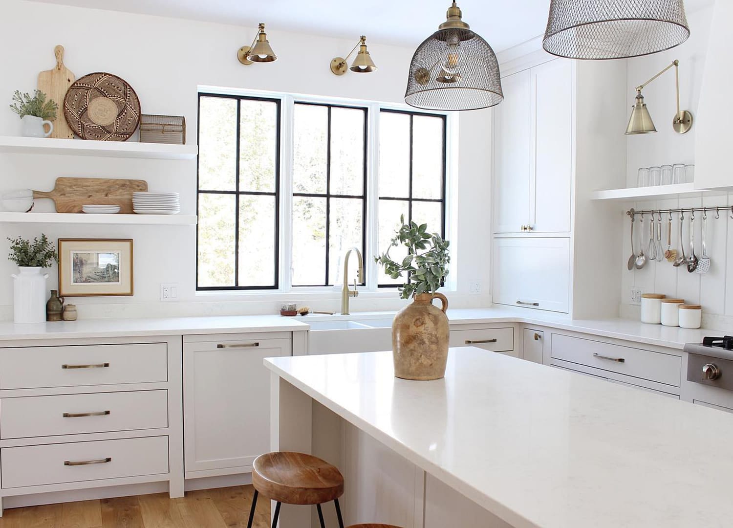 Black grille windows in white kitchen with wood accent pieces