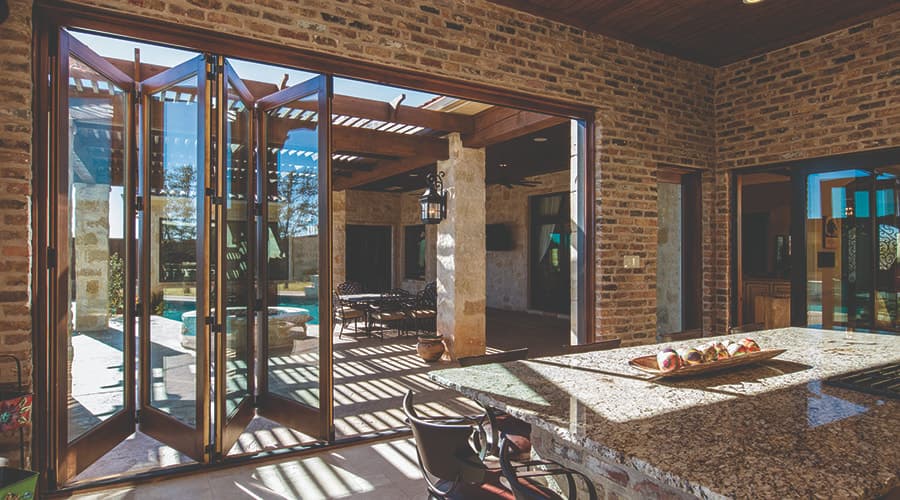 Home in San Antonio has bold and tall Bifold doors that open up home into backyard patio.