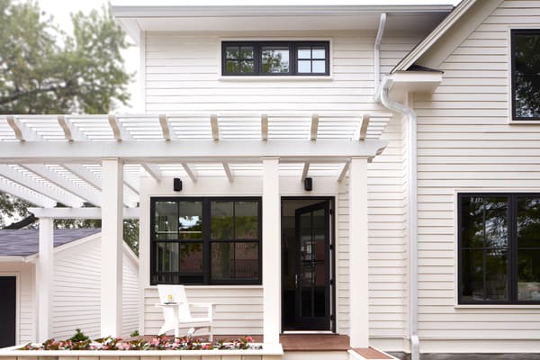 Black hinged patio door on a farmhouse-style home.
