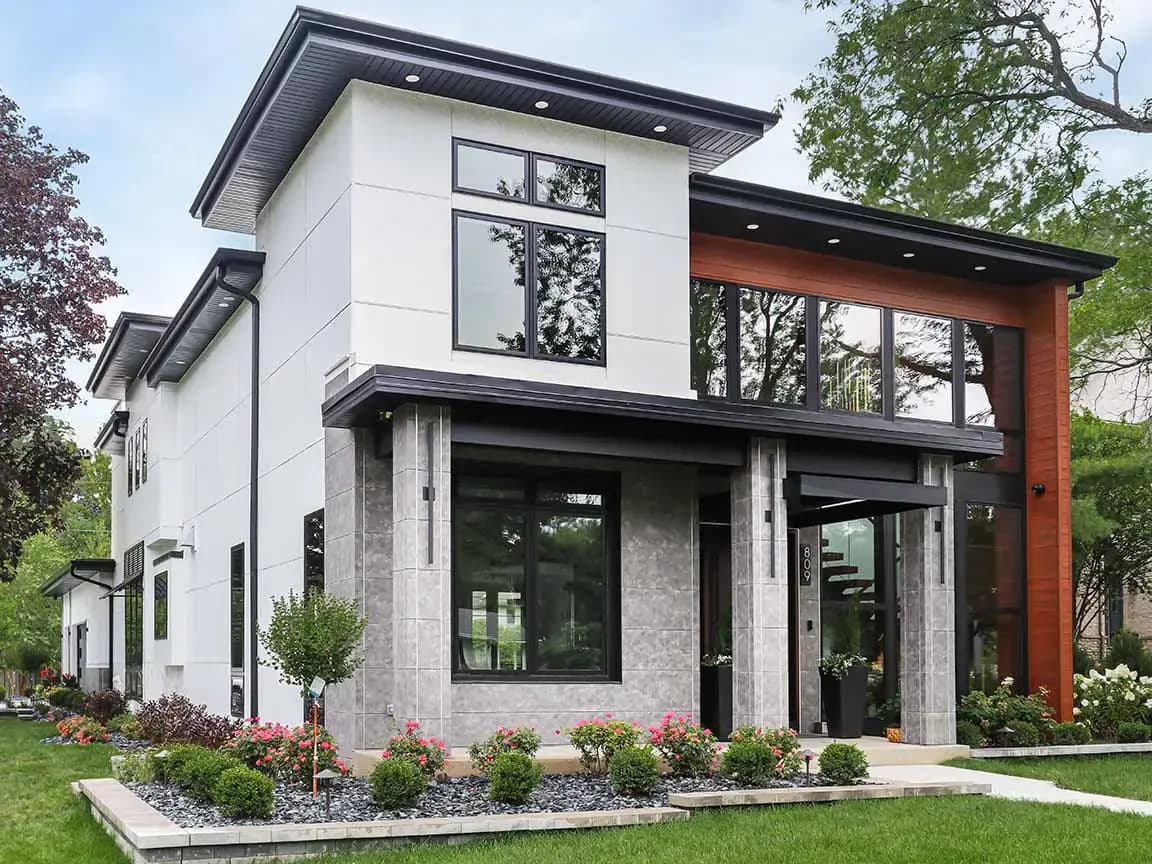 Modern two-story home with black-framed windows, stone columns, and wood accent siding.