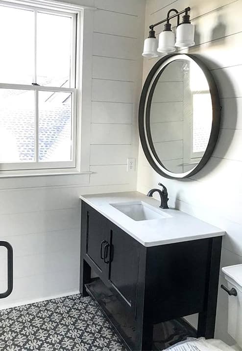 Double-Hung Window Completes Farmhouse Style Bathroom black and white bathroom features white double-hung window and black vanity with black circle mirror above