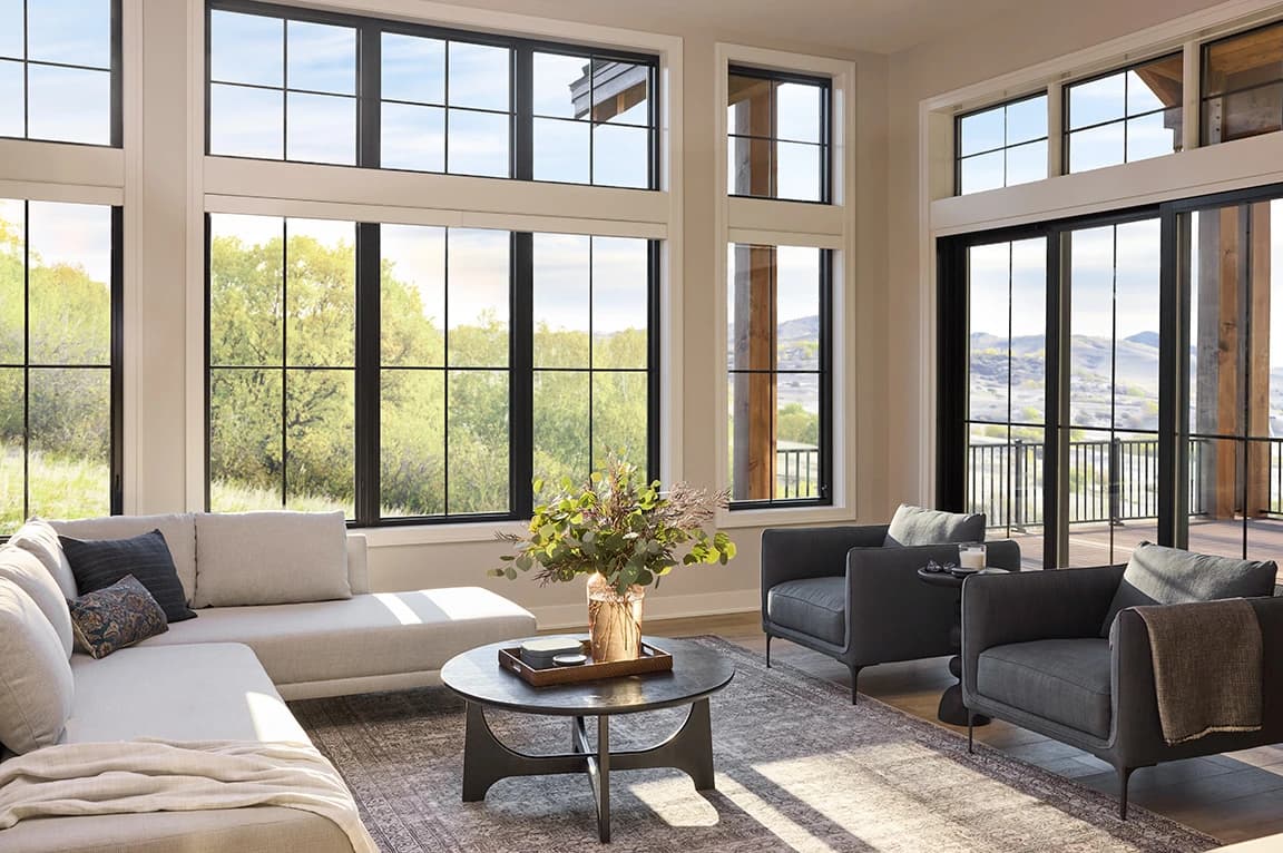 Spacious living room with large windows showcasing parts of a window and scenic outdoor view.