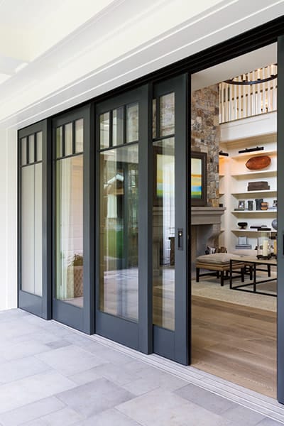 Four panels of a black pocket door with the closest panel partially open