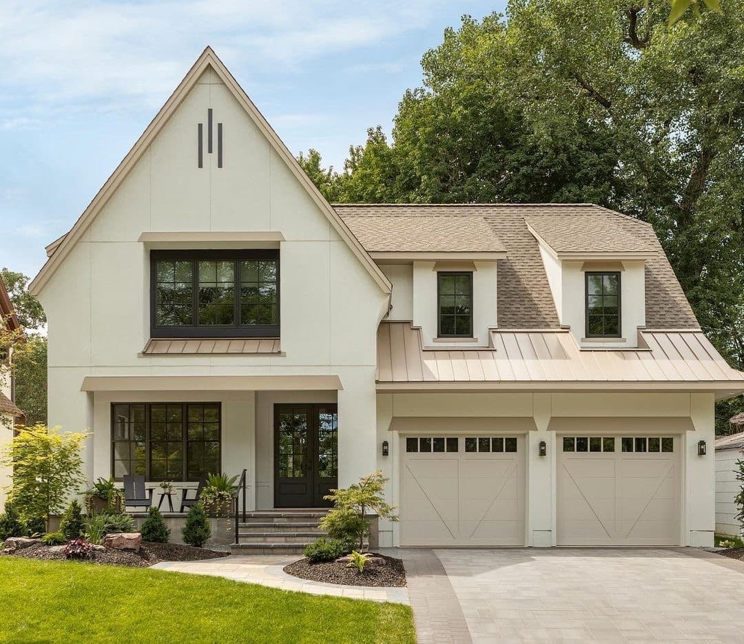The exterior of a cream-colored home features dark gray windows with grilles.
