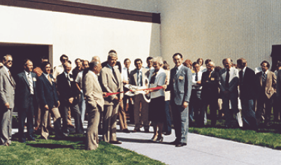 Pella opens a new facility in Carroll, Iowa and the leadership is cutting a ceremonious red ribbon.
