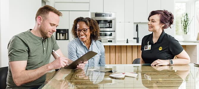 a Pella representative assist a couple for an in-home consultation