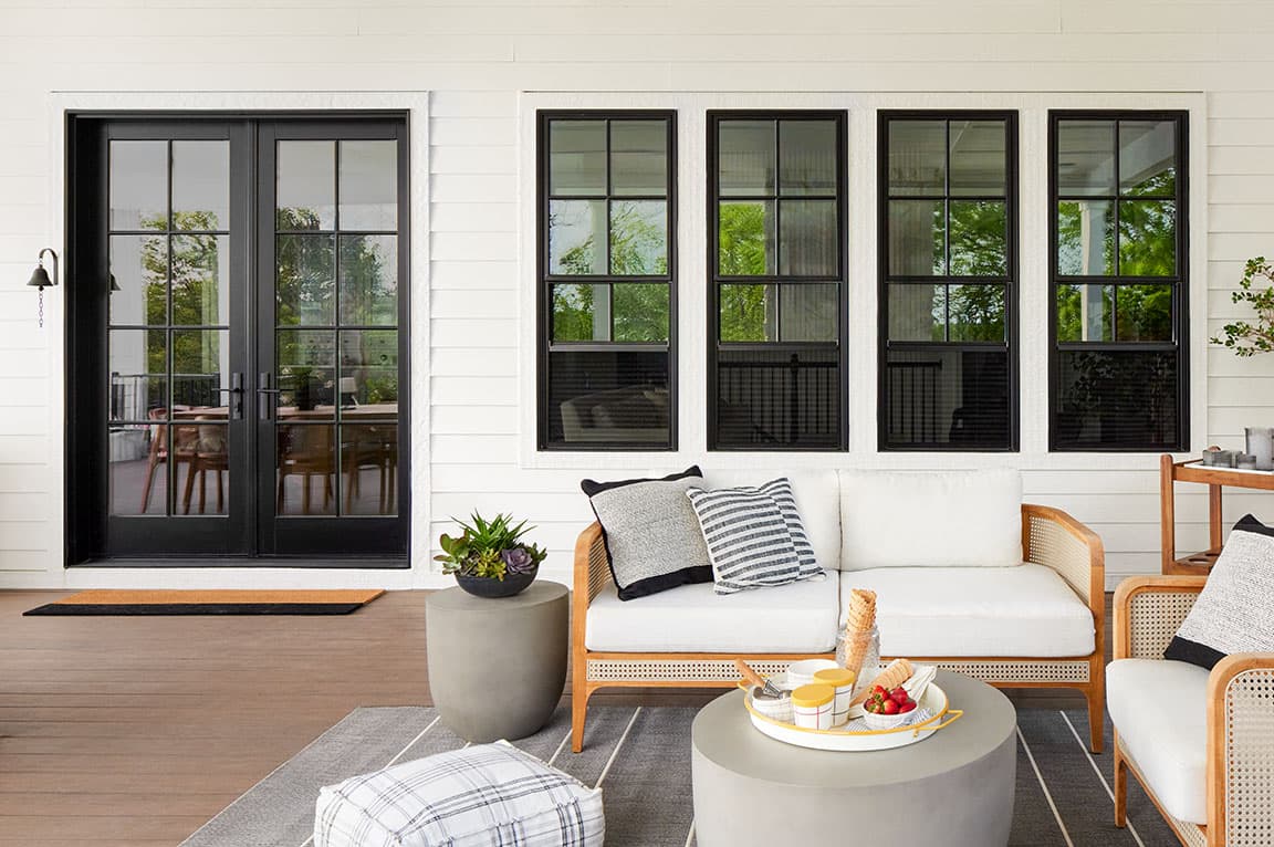 Modern farmhouse with black sliding patio doors, pool area, and a stone path