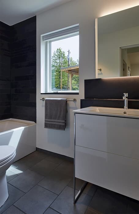 Clean Lines & Durability With Fiberglass Bathroom Window Modern bathroom with dark floor and shower wall and white window and vanity