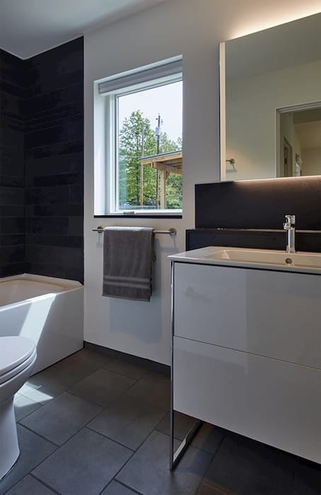 Clean Lines & Durability With Fiberglass Bathroom Window Modern bathroom with dark floor and shower wall and white window and vanity