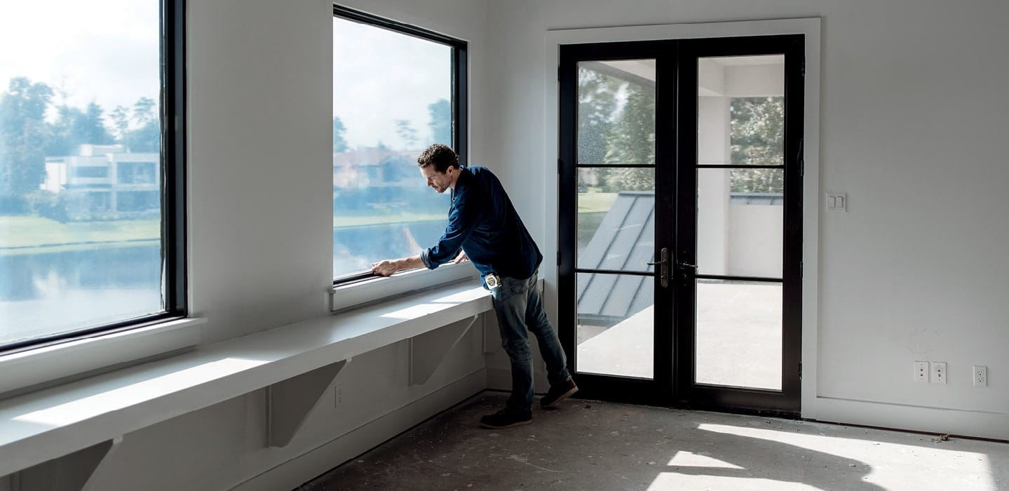 contractor working on a black fixed frame window