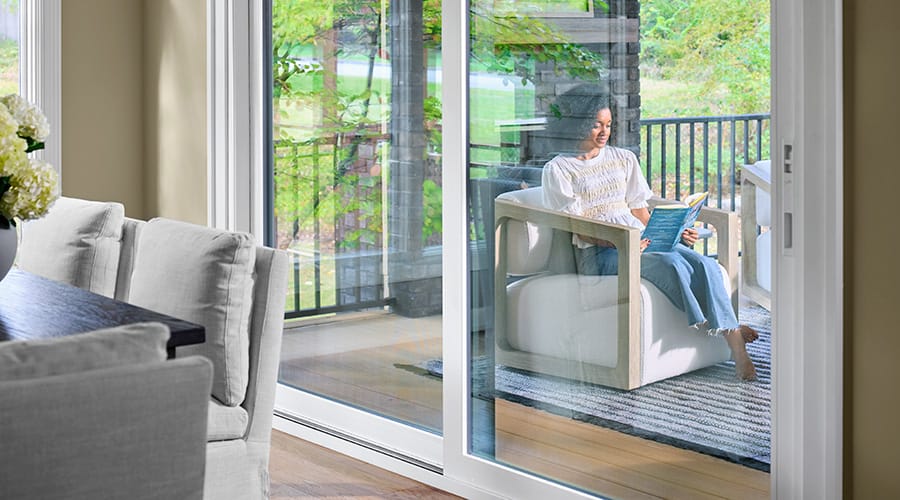 White sliding patio doors opening to a covered porch with outdoor seating.