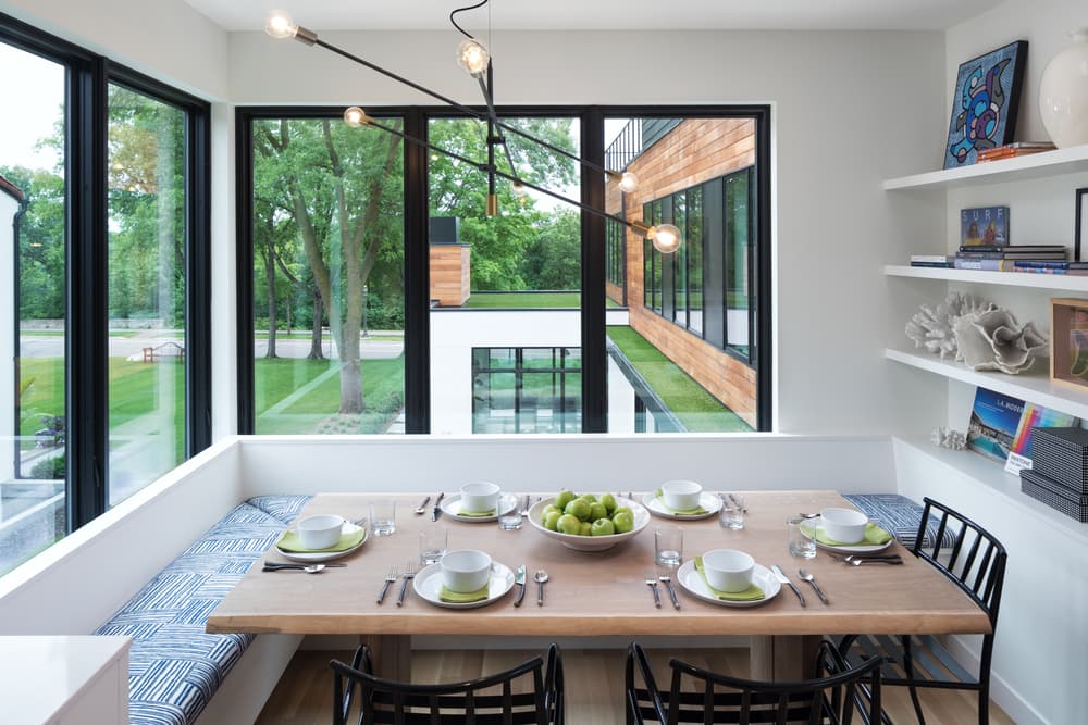 Black Windows Create Contrast For Contemporary Dining Room White dining room nook with benches around the table and tall black casement windows