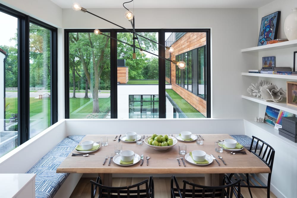 Black Windows Create Contrast For Contemporary Dining Room White dining room nook with benches around the table and tall black casement windows