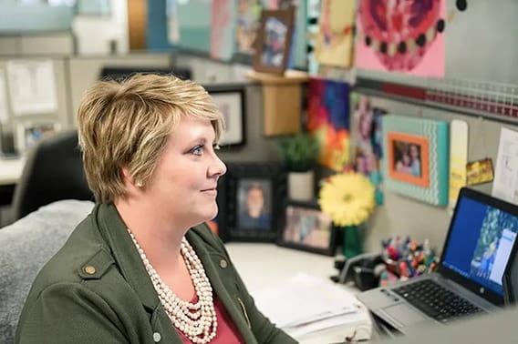 pella employee working in her desk area well decorated