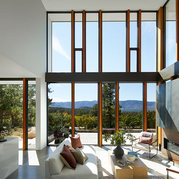Several custom wood windows are combined to create a full floor-to-vaulted-ceiling window wall.