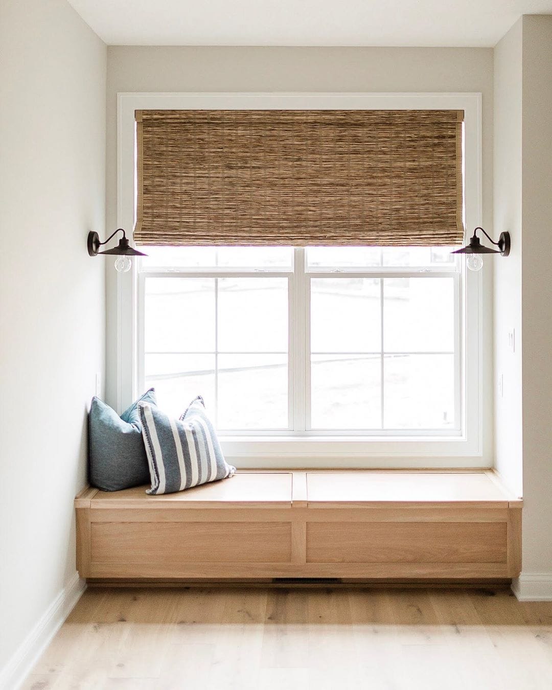 Cozy Farmhouse Window Seat Design window seat with wood bench, white window, and shade