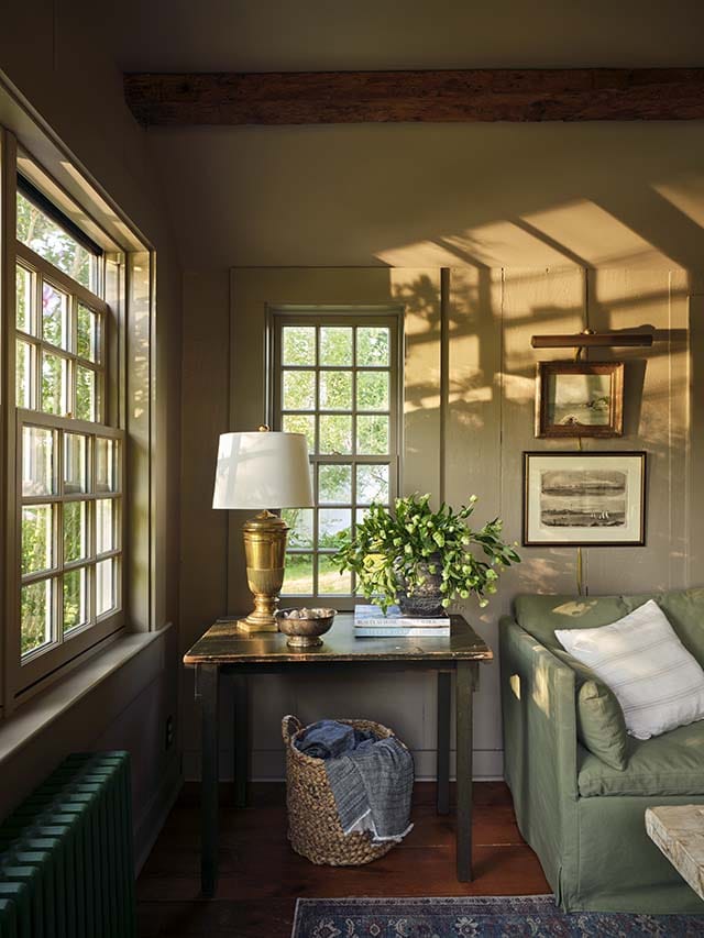 Cozy room with Cape Cod–style windows, warm wood accents, and soft daylight.