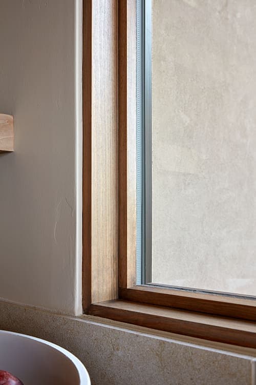 A close shot of a wood window sill that frames a picture window.