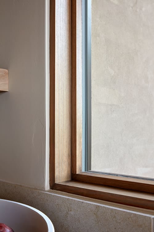 A close shot of a wood window sill that frames a picture window.