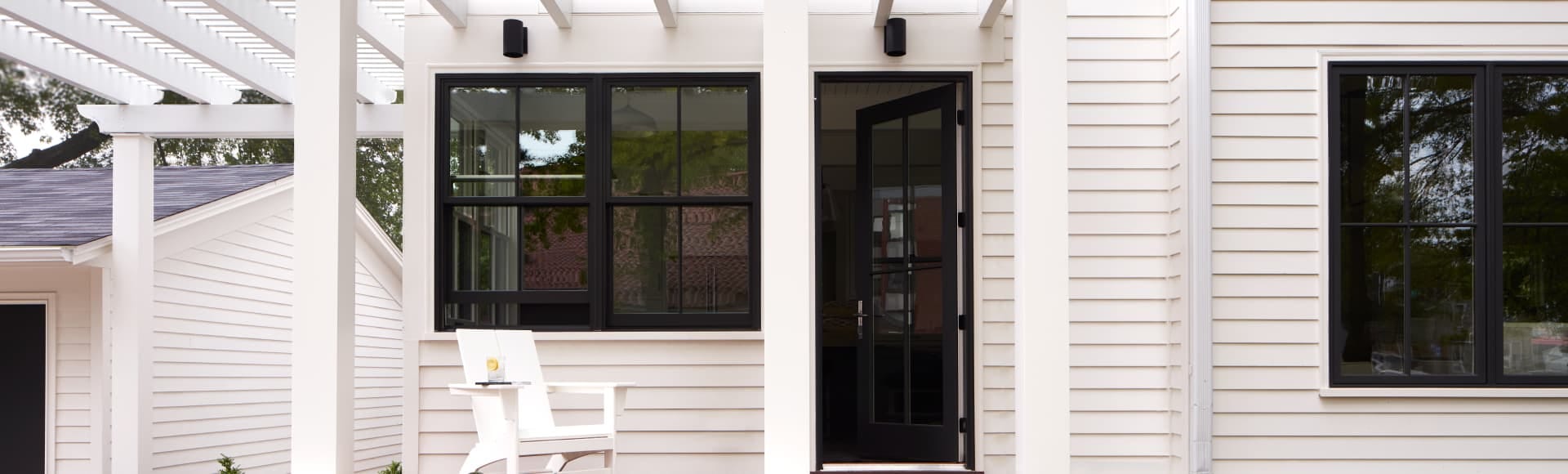 white home with black-trimmed windows and a black-trimmed hinged door
