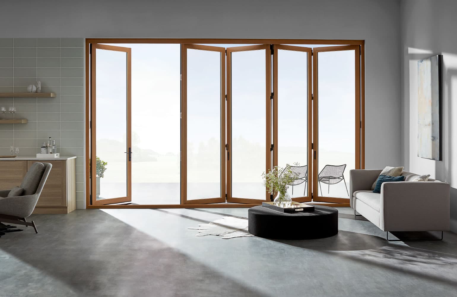 Bifold Patio Doors Seamlessly Connect Indoors To Outdoors living room with light wood stained bifold patio doors partly open