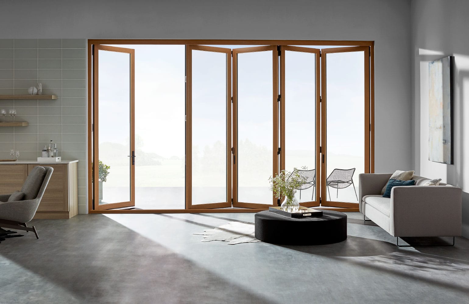 Bifold Patio Doors Seamlessly Connect Indoors To Outdoors living room with light wood stained bifold patio doors partly open