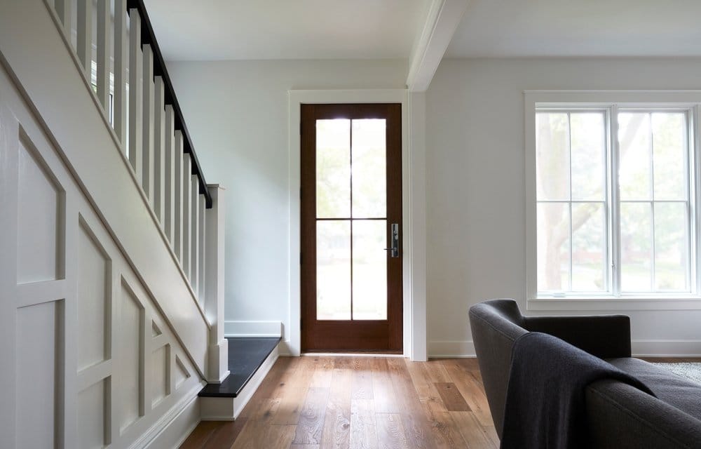 Wood Entry Door And Windows Feature Authentic Details white farmhouse style entryway with stairs leading to stained wood glass front door