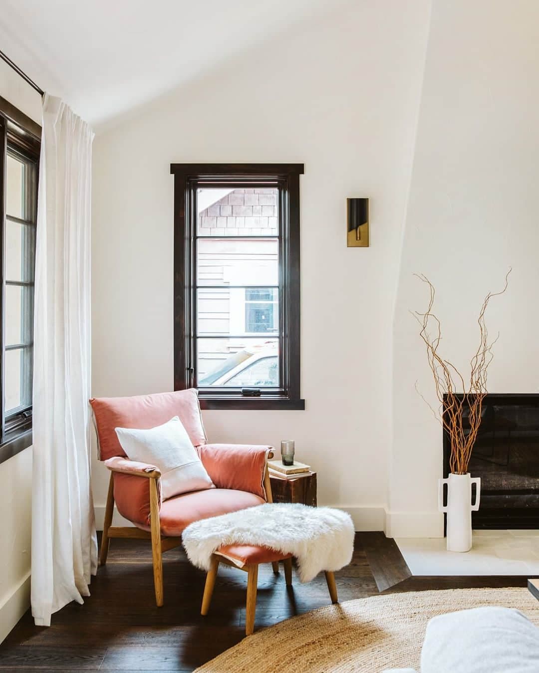 Black Casement Window Adds Drama To Cozy Corner corner of living room with black casement window and red upholstered chair