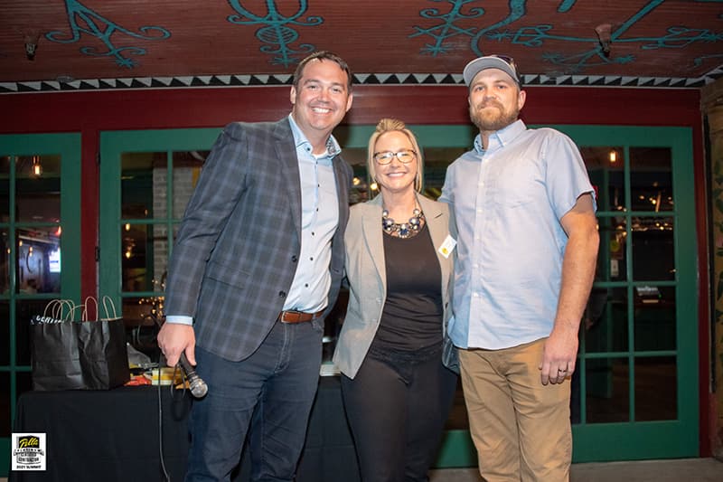 two pella sales team members congratulate taylor richards on his success