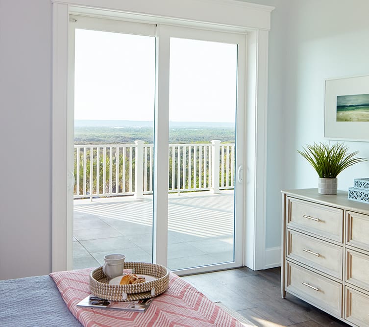 a white french door opening from a traditional bedroom to a small balcony