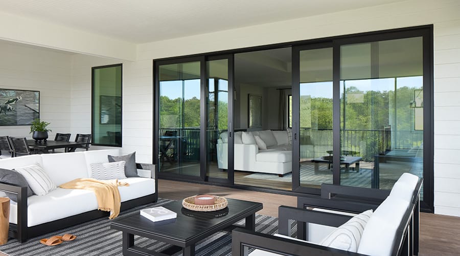 Close-up view of modern black sliding patio door hardware next to a stone accent wall.