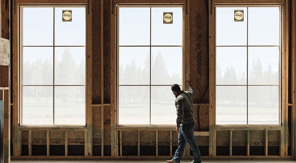 a young contractor stands in the newly installed Pella windows