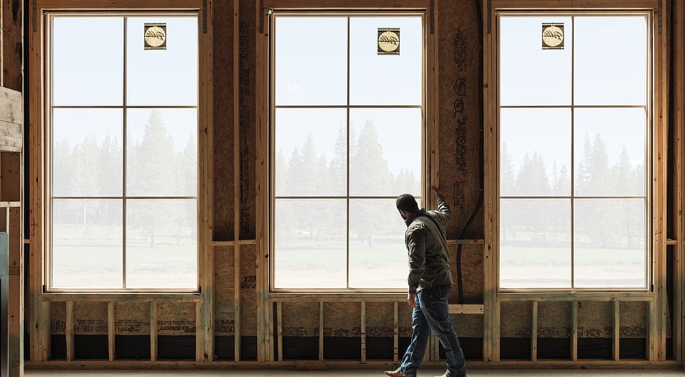 a young contractor stands in the newly installed Pella windows