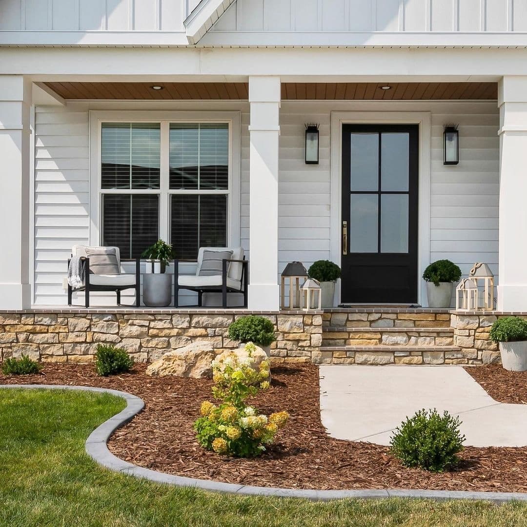 A white farmhouse window backs a charming seating area on the front porch.