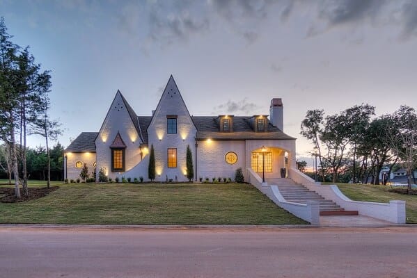 Circle Windows & Classic Grilles Highlight Design Details New construction home with custom shape windows lit up at dusk