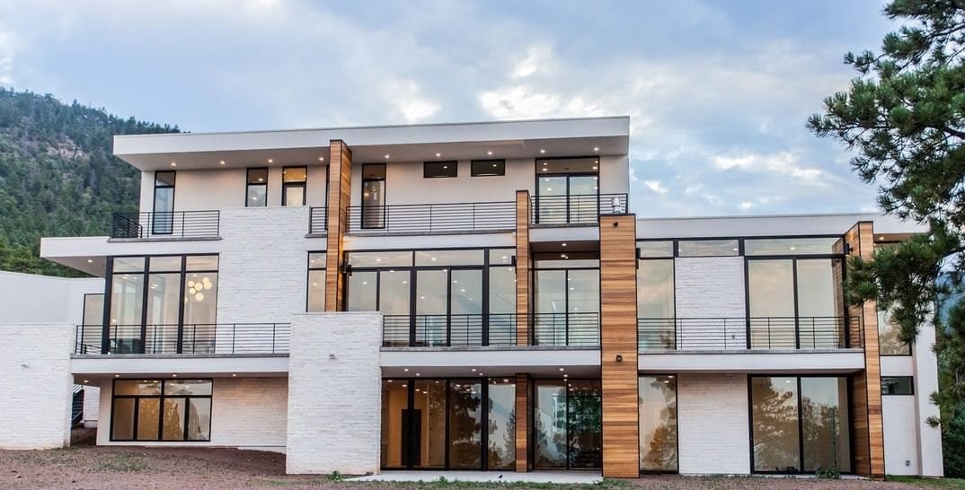 Modern black windows and sliding patio doors on the exterior of a white home.