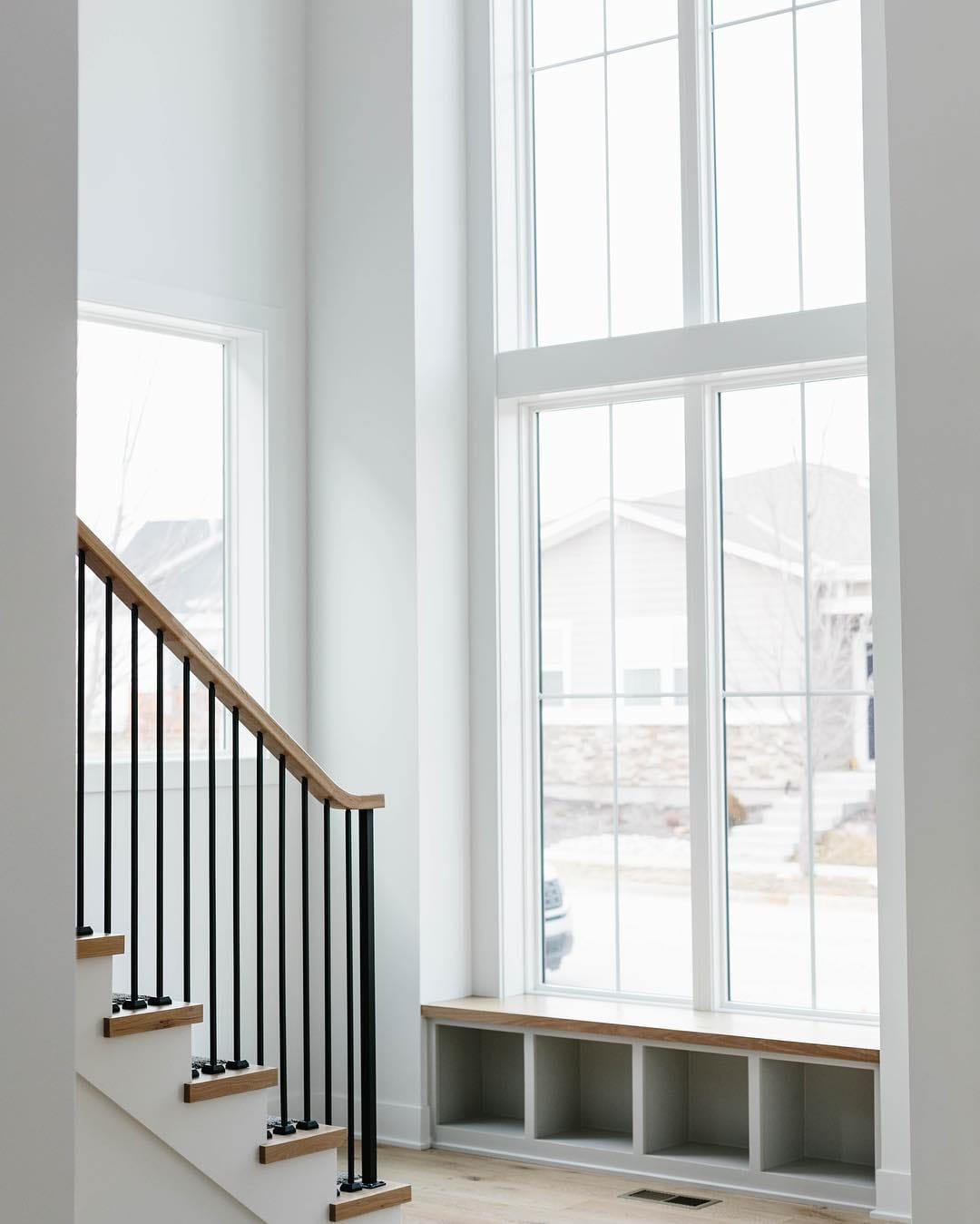 Stacked Picture Windows Create Modern Farmhouse Design stacked picture windows with shoe cubbies underneath at the bottom of stairs