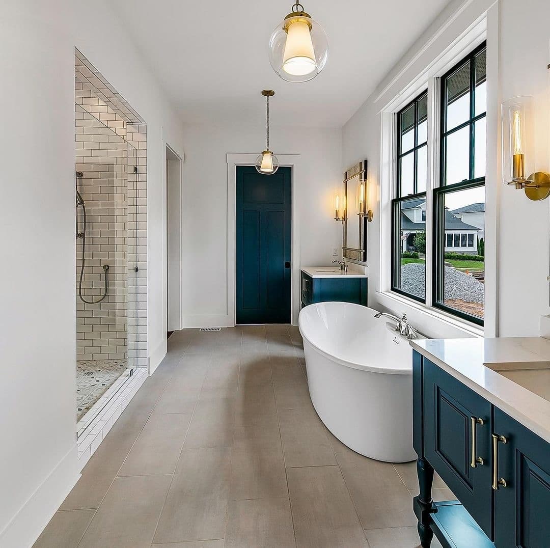 Two black double-hung windows are placed on the wall above a white bathtub.
